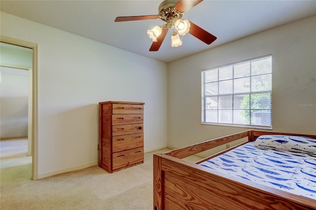 bedroom with light carpet, a ceiling fan, and baseboards