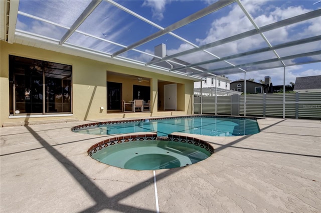 view of swimming pool with a patio, a lanai, fence, a ceiling fan, and a pool with connected hot tub