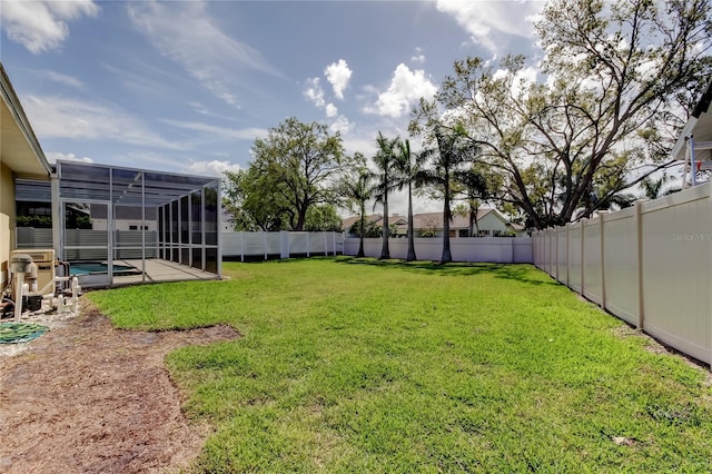 view of yard with a swimming pool, a fenced backyard, and a lanai