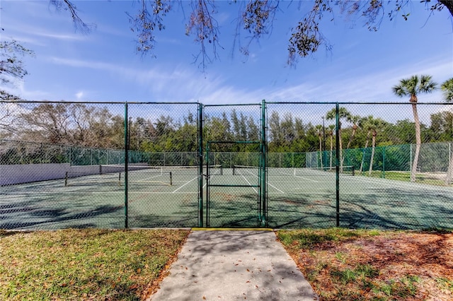 view of sport court with a gate and fence