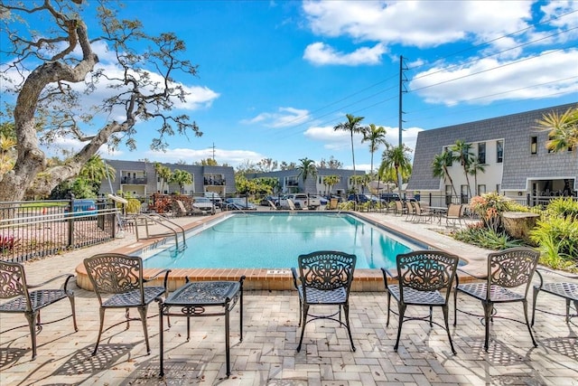 pool with a patio area and fence