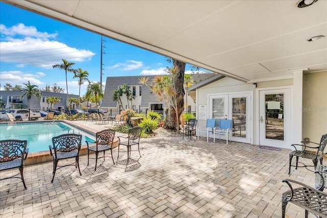 view of patio with fence and a community pool