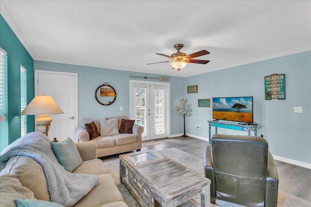 living room featuring french doors, crown molding, baseboards, and wood finished floors