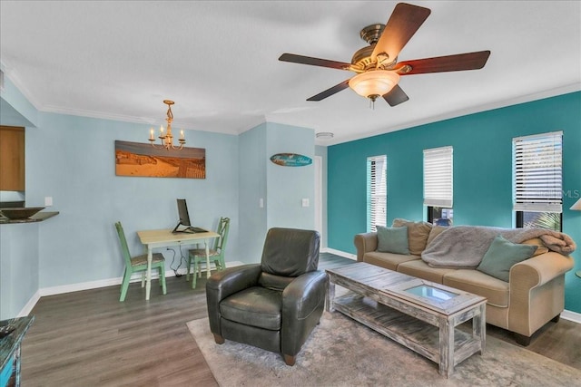 living area featuring crown molding, baseboards, wood finished floors, and ceiling fan with notable chandelier