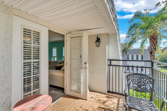 property entrance with a balcony and stucco siding