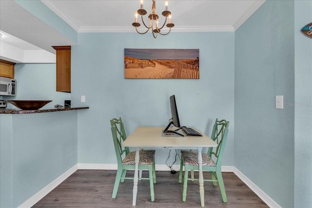 dining area with ornamental molding, dark wood-style flooring, a notable chandelier, and baseboards