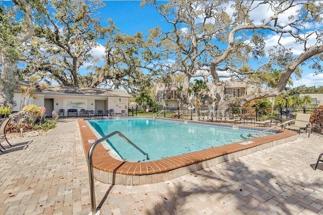 community pool with fence and a patio