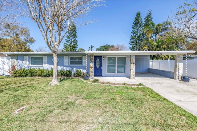 view of front of property featuring driveway, fence, a front lawn, and an attached carport