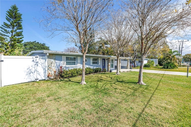 ranch-style home with a carport, concrete driveway, a front lawn, and fence