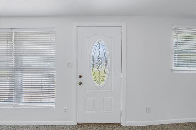 foyer featuring baseboards and speckled floor