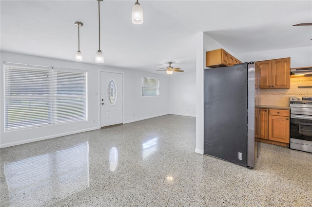 kitchen with brown cabinetry, plenty of natural light, stainless steel appliances, and light speckled floor