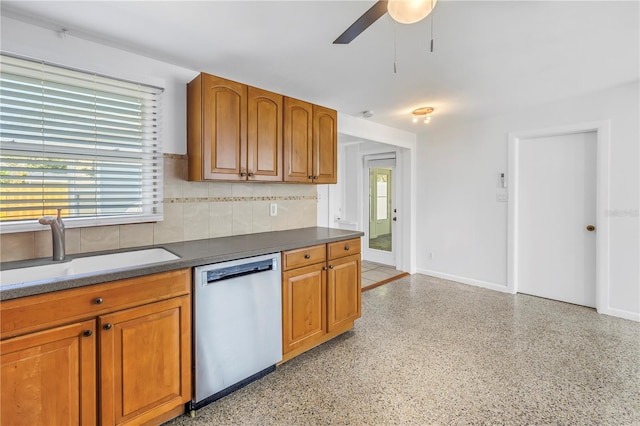 kitchen featuring brown cabinetry, dishwasher, and a sink