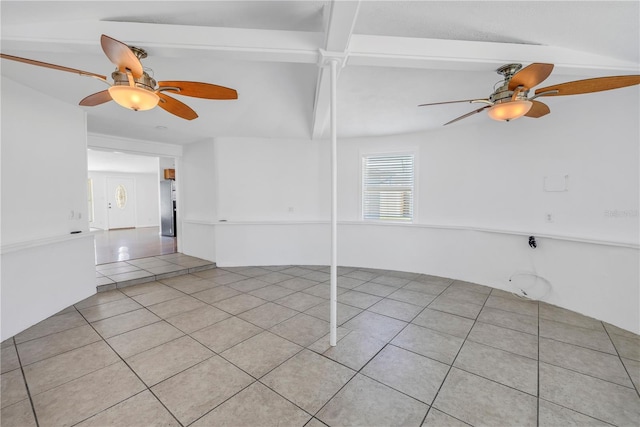 tiled empty room featuring a ceiling fan and beam ceiling