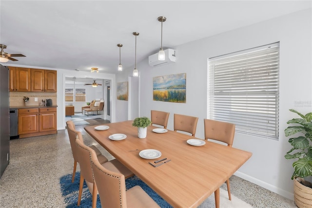 dining area featuring light speckled floor, an AC wall unit, ceiling fan, and baseboards