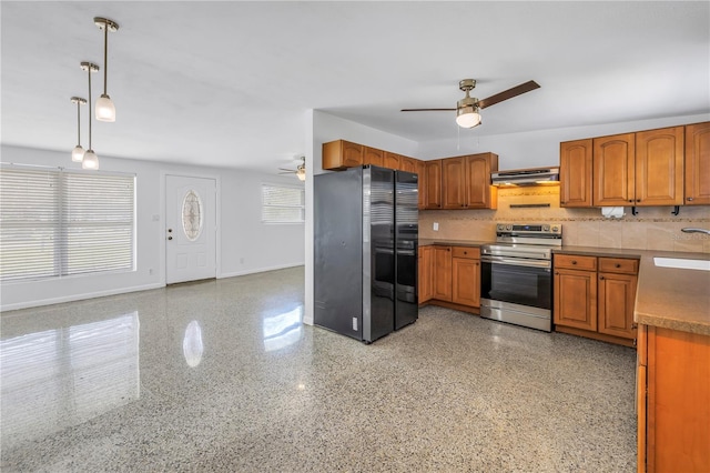 kitchen featuring electric range, brown cabinets, freestanding refrigerator, and under cabinet range hood