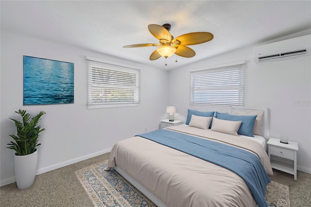 bedroom with a wall mounted AC, a ceiling fan, and baseboards