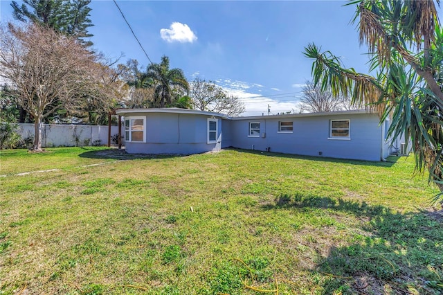 rear view of property with a yard and fence