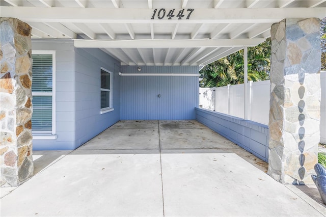 view of patio / terrace featuring fence and an attached carport