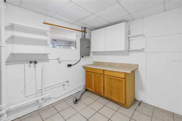 washroom featuring cabinet space, electric panel, and light tile patterned floors