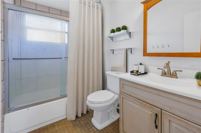 bathroom featuring toilet, combined bath / shower with glass door, and vanity