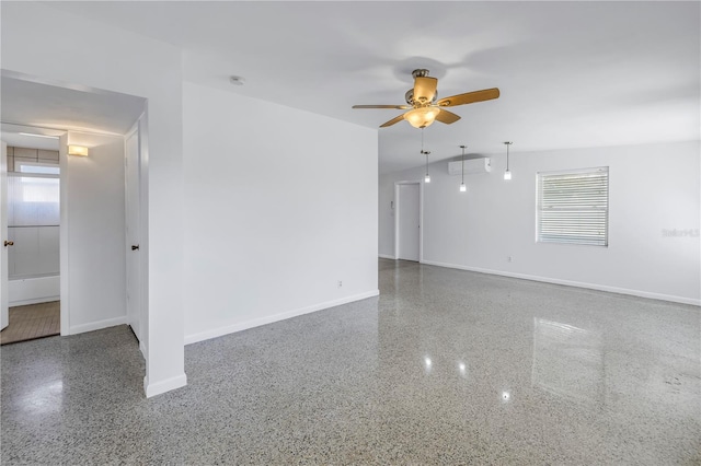 spare room featuring a healthy amount of sunlight, baseboards, a ceiling fan, and speckled floor