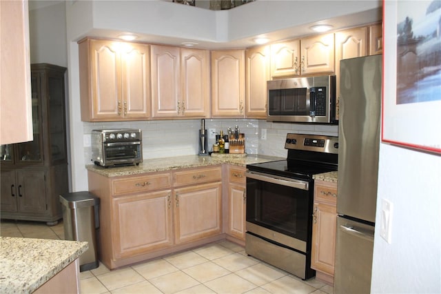 kitchen featuring stainless steel appliances and light brown cabinetry