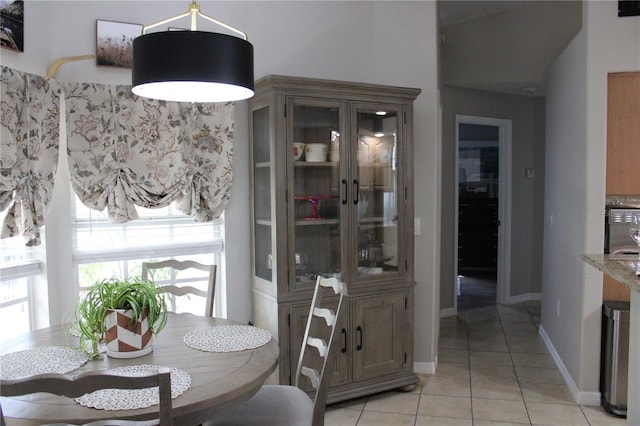 dining area with light tile patterned flooring and baseboards