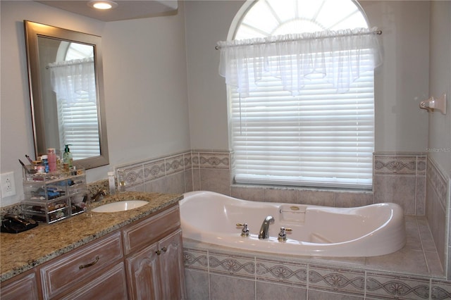 full bathroom featuring a garden tub and vanity