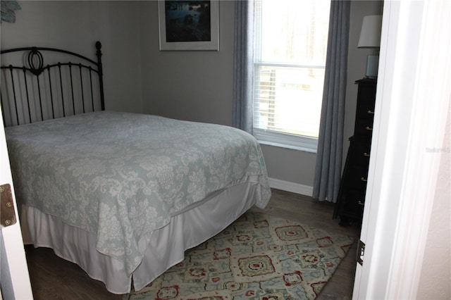 bedroom with baseboards and wood finished floors