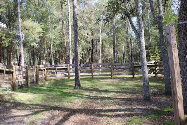 view of yard featuring fence and a forest view