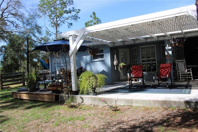 rear view of property with fence, a deck, and a pergola