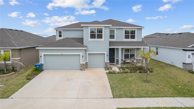 view of front of home featuring covered porch, driveway, stone siding, stucco siding, and a front lawn