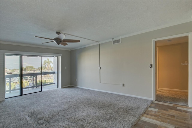 carpeted spare room featuring crown molding, visible vents, a ceiling fan, a textured ceiling, and baseboards