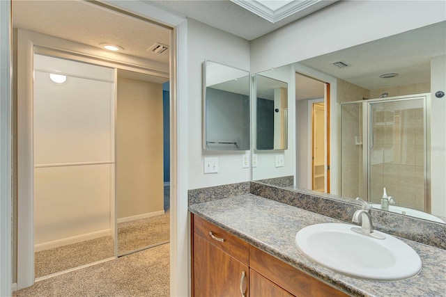 bathroom featuring visible vents, a shower stall, vanity, and baseboards