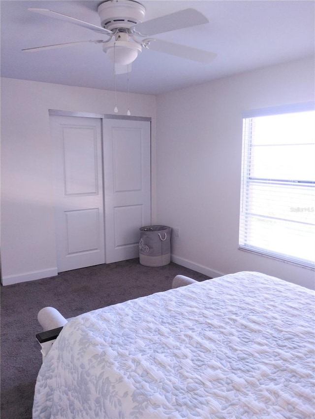 bedroom with a closet, carpet flooring, ceiling fan, and baseboards