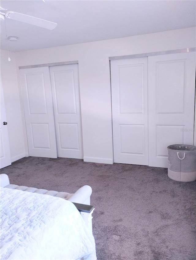 carpeted bedroom featuring baseboards, a ceiling fan, and multiple closets