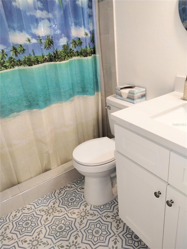 bathroom with toilet, vanity, a shower with shower curtain, and tile patterned floors