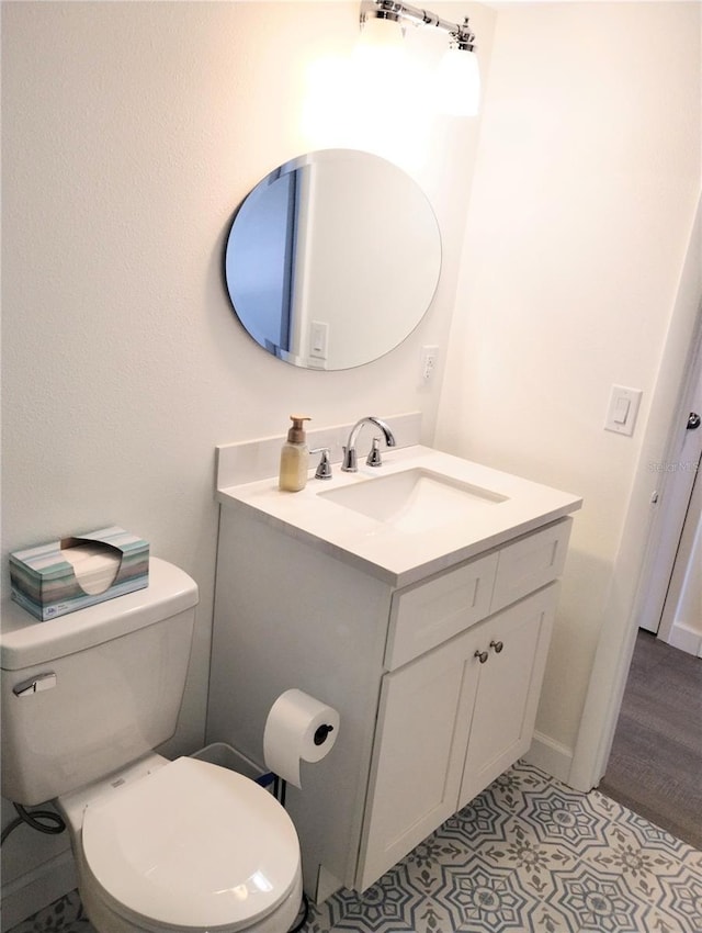 bathroom with toilet, vanity, and tile patterned floors