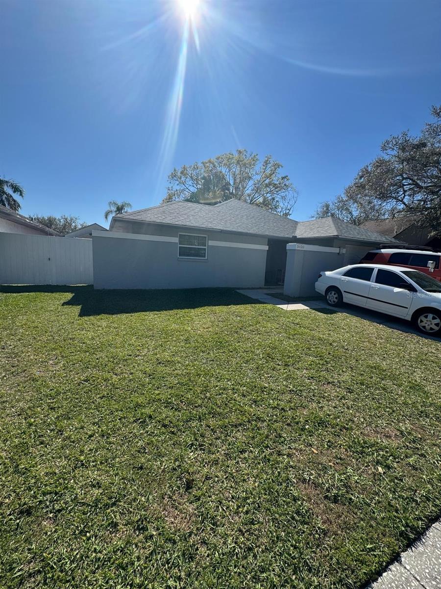 view of home's exterior featuring stucco siding, fence, and a yard