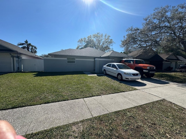 view of side of property with a lawn, concrete driveway, and stucco siding