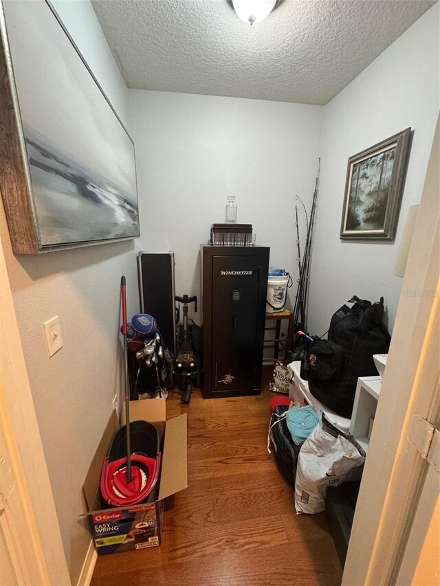 miscellaneous room with a textured ceiling and wood finished floors