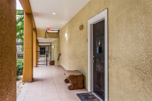 entrance to property featuring fence and stucco siding