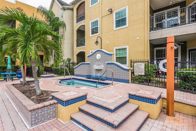 exterior space with a community hot tub, a patio area, and fence