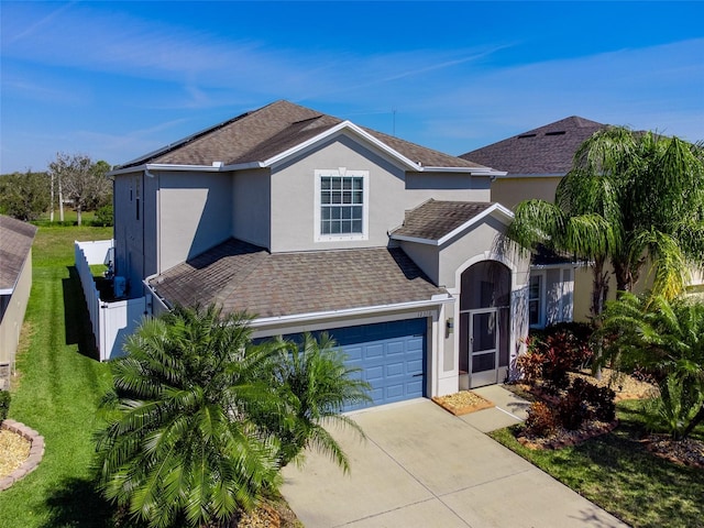 traditional-style home with a garage, roof with shingles, concrete driveway, and stucco siding