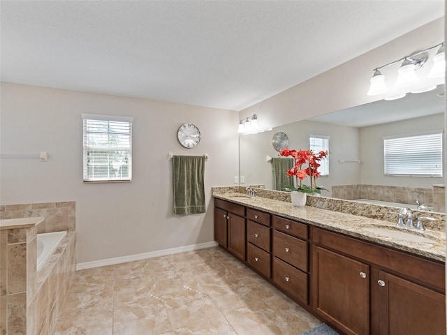 bathroom with a bath, a sink, and a wealth of natural light