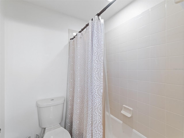 bathroom featuring shower / tub combo with curtain and toilet