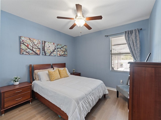 bedroom featuring ceiling fan, baseboards, and wood finished floors