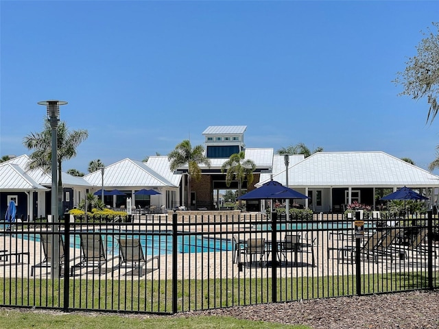 community pool with fence and a patio