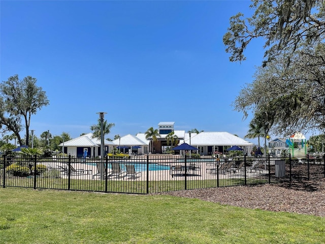 community pool with a yard and fence