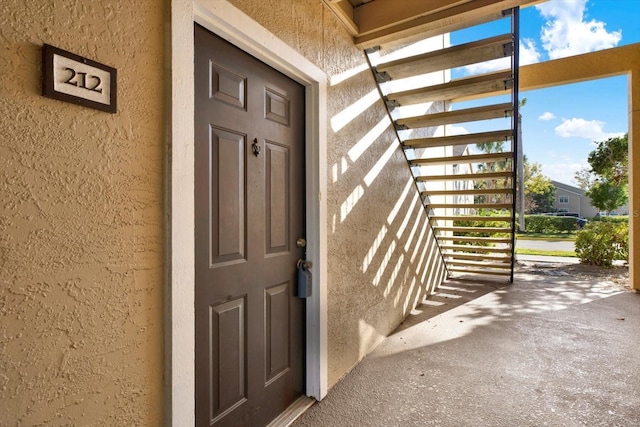 entrance to property featuring stucco siding